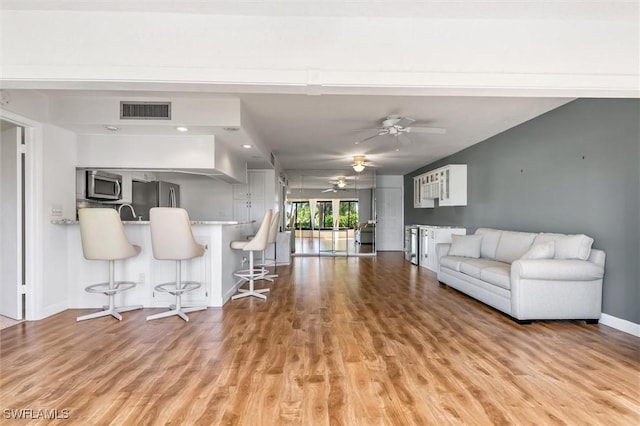 unfurnished living room featuring ceiling fan and light hardwood / wood-style flooring