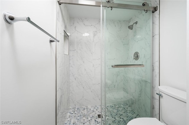 bathroom featuring an enclosed shower and toilet