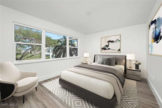 bedroom with hardwood / wood-style floors and multiple windows