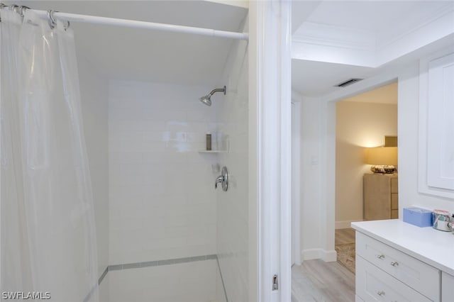 bathroom featuring ornamental molding, a shower with shower curtain, wood-type flooring, and vanity