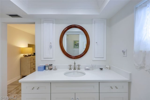 bathroom with tile floors, vanity, and a raised ceiling