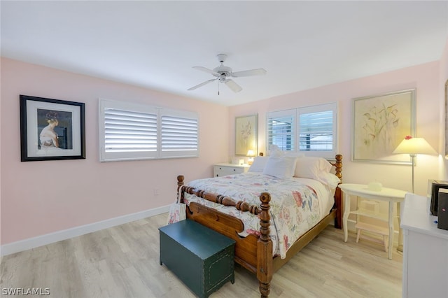 bedroom with ceiling fan, light hardwood / wood-style floors, and multiple windows