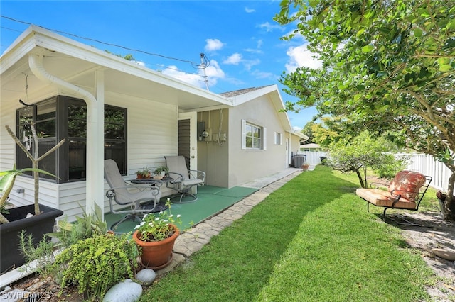 rear view of house featuring a patio area and a yard