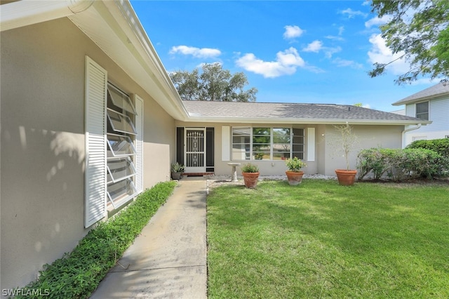 property entrance featuring a lawn