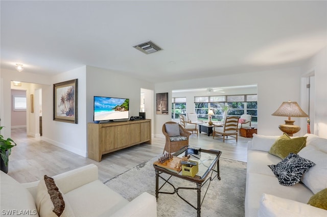 living room featuring hardwood / wood-style floors and ceiling fan