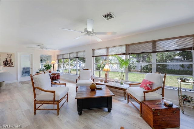 living room with a wealth of natural light, light hardwood / wood-style floors, and ceiling fan