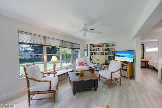 living room with light hardwood / wood-style flooring and ceiling fan