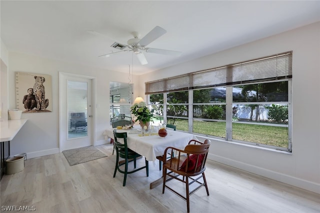 dining room with ceiling fan and light wood-type flooring