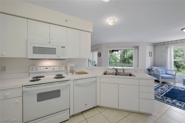 kitchen featuring kitchen peninsula, white appliances, white cabinets, sink, and light tile floors