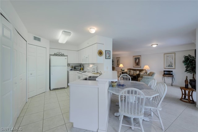 kitchen with kitchen peninsula, white appliances, light tile flooring, white cabinets, and sink