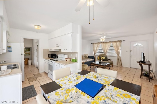 kitchen with white cabinetry, light tile patterned floors, and white range with electric cooktop