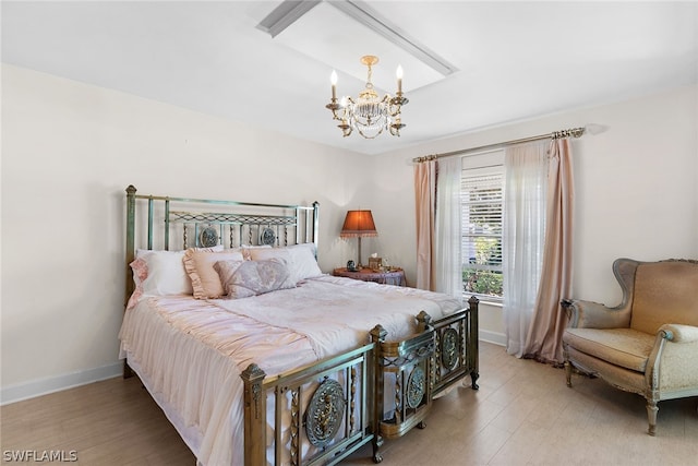 bedroom featuring an inviting chandelier and hardwood / wood-style flooring