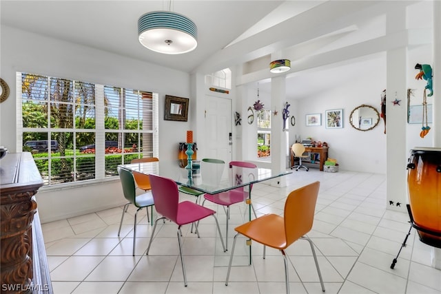 dining area featuring light tile patterned floors and vaulted ceiling