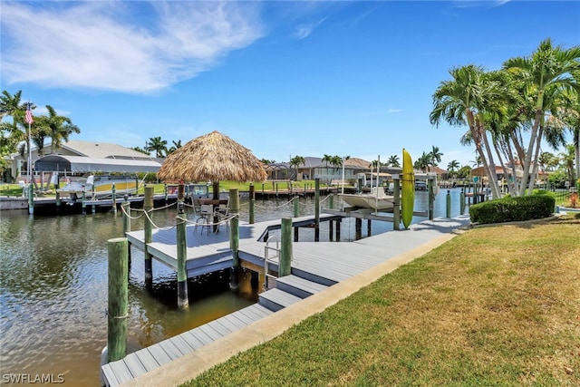 view of dock with a lawn and a water view