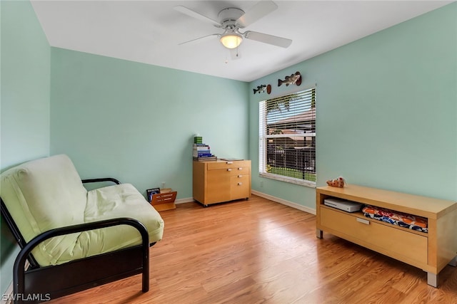 living area with ceiling fan and light hardwood / wood-style flooring