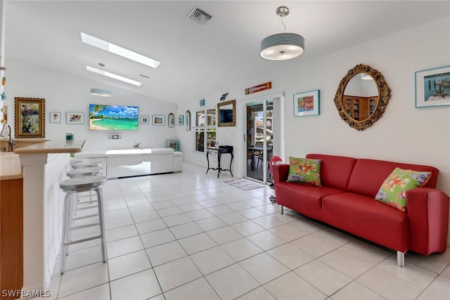 living room featuring lofted ceiling with skylight and light tile patterned flooring