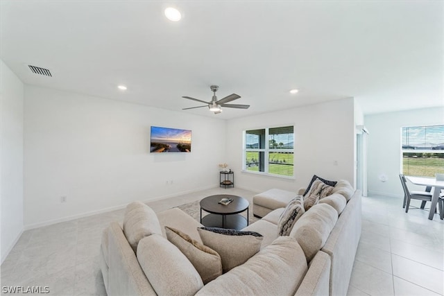 tiled living room with a wealth of natural light and ceiling fan