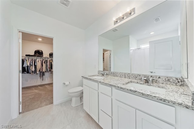 bathroom featuring tile floors, toilet, and dual vanity