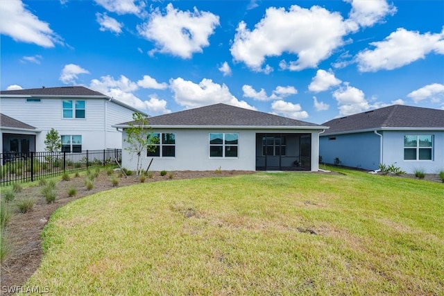 rear view of property with a yard and a sunroom