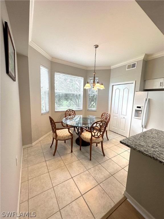 tiled dining room featuring a notable chandelier and crown molding