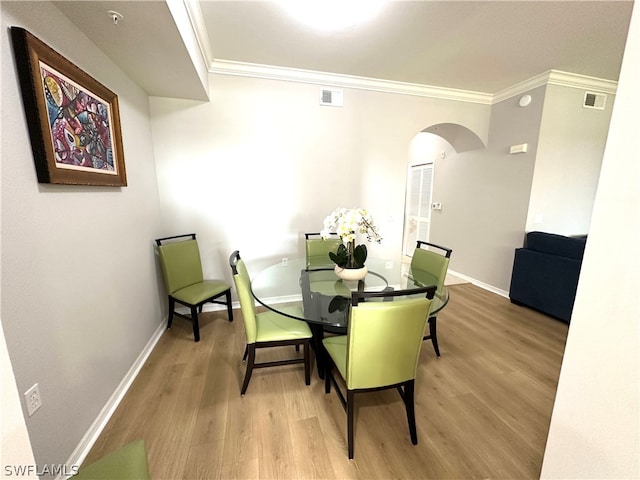 dining room with ornamental molding and hardwood / wood-style floors