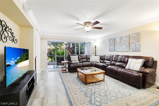 living room with a textured ceiling, hardwood / wood-style floors, ceiling fan, and crown molding