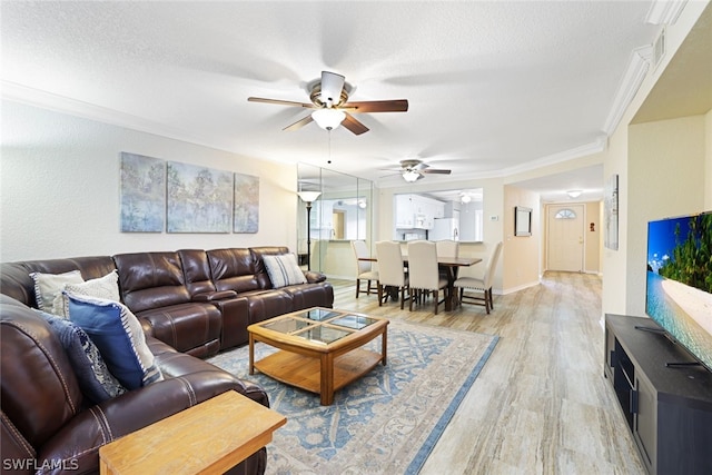 living room with ornamental molding, wood-type flooring, ceiling fan, and a textured ceiling