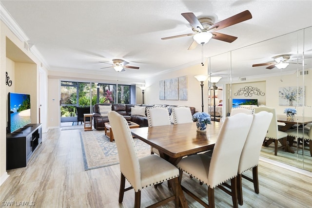 dining room featuring a textured ceiling, ceiling fan, light wood-type flooring, and ornamental molding