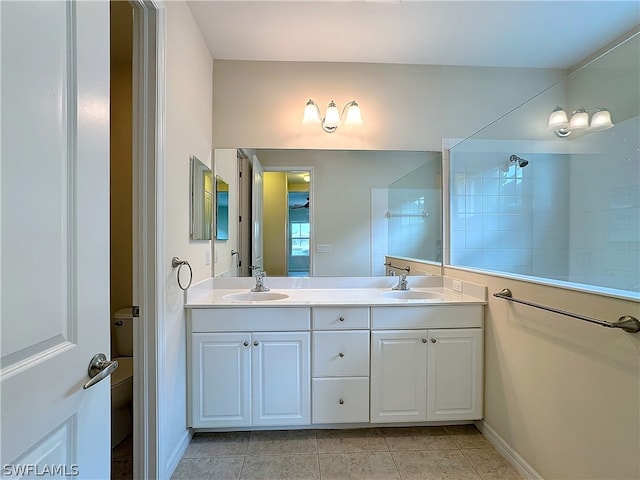 bathroom featuring tile flooring, oversized vanity, toilet, and dual sinks