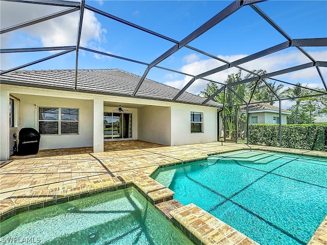 view of swimming pool with a patio area, ceiling fan, and glass enclosure