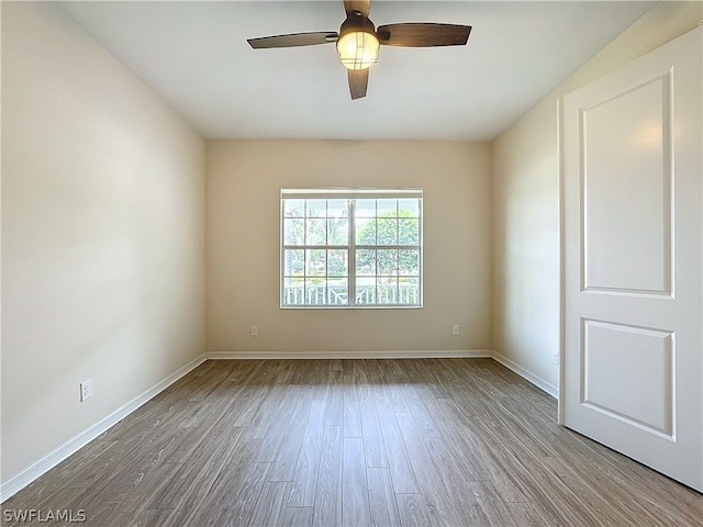 empty room with hardwood / wood-style floors and ceiling fan