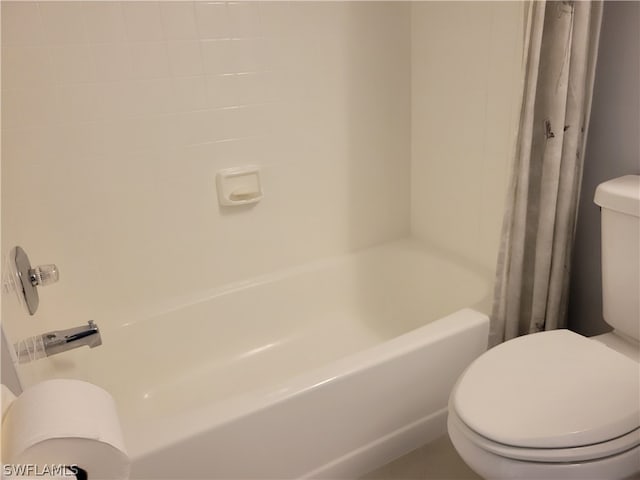 bathroom featuring shower / tub combo and toilet