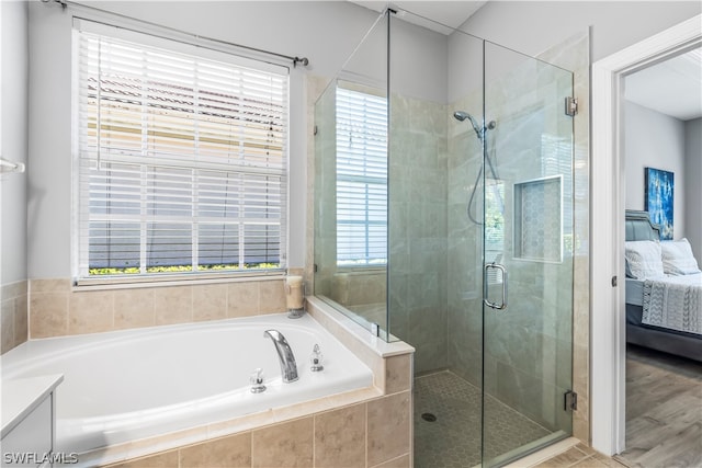 bathroom featuring wood-type flooring, vanity, and plus walk in shower