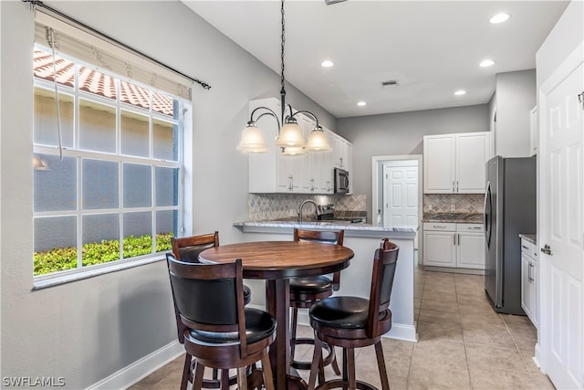 dining area featuring light tile patterned flooring, a chandelier, and a wealth of natural light