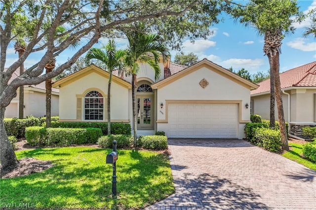 mediterranean / spanish home with a garage and a front yard