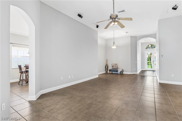 unfurnished living room with ceiling fan and dark tile patterned flooring