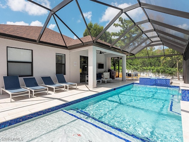 view of pool featuring a patio, ceiling fan, and glass enclosure