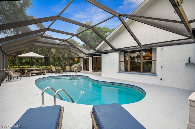 view of swimming pool featuring a patio area and glass enclosure