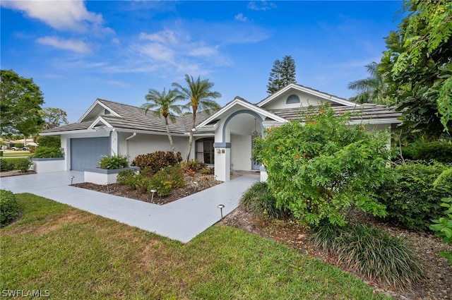 view of front of home with a garage and a front lawn