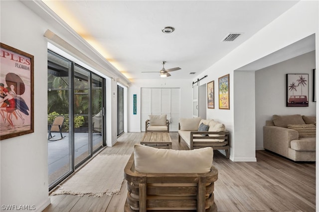 living room featuring ceiling fan and light hardwood / wood-style flooring