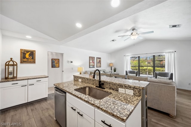 kitchen with ceiling fan, sink, stainless steel dishwasher, vaulted ceiling, and an island with sink