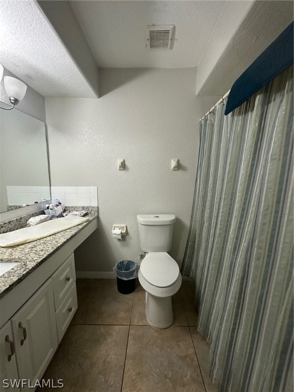 bathroom featuring toilet, tile flooring, and vanity