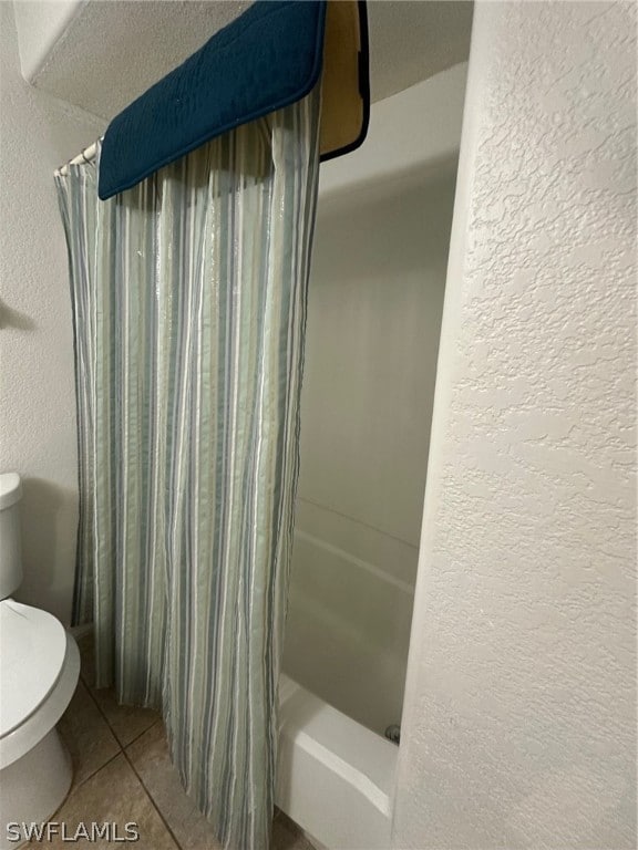 bathroom featuring shower / tub combo with curtain, toilet, and tile flooring