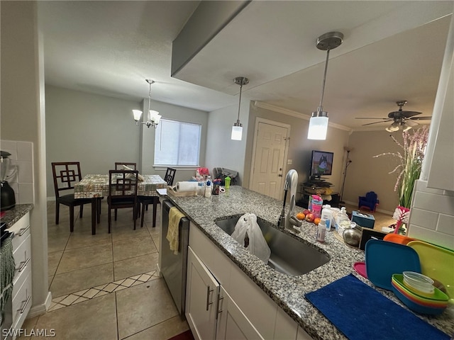 kitchen featuring hanging light fixtures, white cabinetry, ornamental molding, light tile floors, and sink