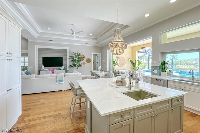 kitchen featuring sink, light hardwood / wood-style flooring, and a raised ceiling