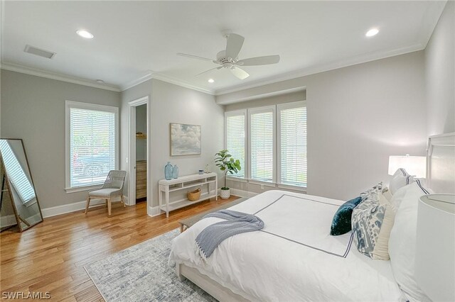 bedroom featuring light hardwood / wood-style flooring, ornamental molding, ceiling fan, and multiple windows