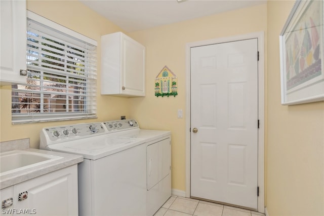 laundry room featuring independent washer and dryer, cabinets, and light tile floors