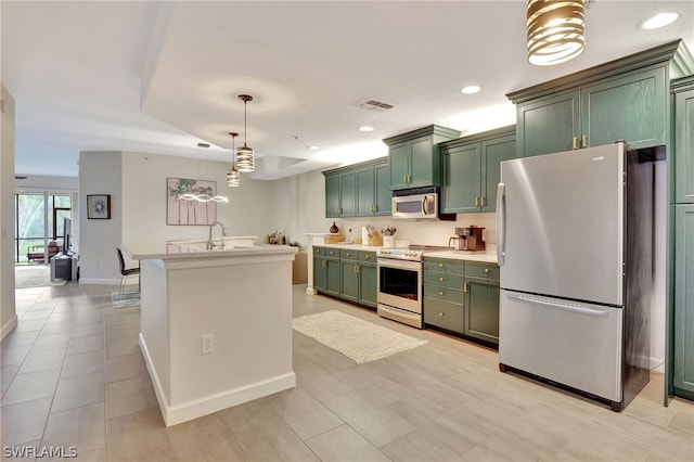 kitchen with hanging light fixtures, appliances with stainless steel finishes, sink, and green cabinetry