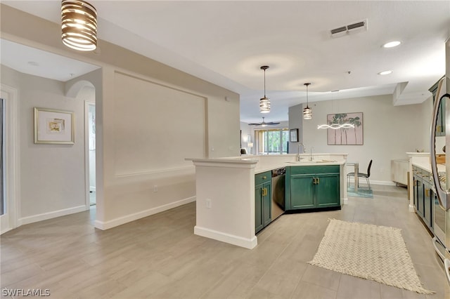 kitchen with green cabinetry, a center island with sink, dishwashing machine, hanging light fixtures, and sink