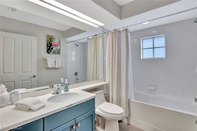 full bathroom with shower / tub combo with curtain, toilet, and vanity with extensive cabinet space